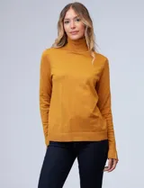 Polera de punto fino marca Nienty, color blanco, con cuello alto volcado y mangas largas con detalle de tajo en los puños.