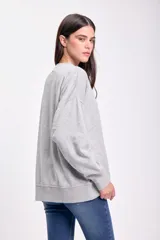 Buzo deportivo de algodón color gris claro con estampa frontal con texto en color crema.