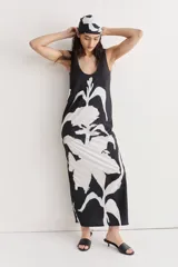 Vestido largo de seda con estampado floral abstracto en blanco sobre fondo negro, escote redondo y corte recto.