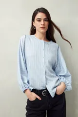 Camisa blanca a rayas grises, de lino, con cuello mao, mangas largas abullonadas y bordados en las sisas.