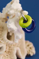 Aros colgantes hechos a mano con cristal de Murano, con forma de aros de color verde lima y azul. El aro que sujeta los cristales es de acero quirúrgico.