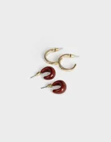 Set de dos pares de aros argollas: un par de argollas gruesas color borgoña y un par de argollas doradas con textura. Cierre de tope a presión.