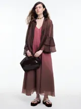 Camisa negra de lyocell y poliamida, con cuello clásico, mangas largas acampanadas con volados y cierre frontal con botones.