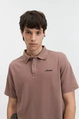 Chomba gris con textura tipo waffle, corte regular y logo bordado en el pecho.