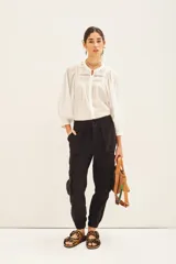 Pantalón negro de corte holgado con bolsillos laterales y en las piernas, cintura elástica y ruedo con elástico interno.