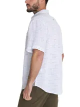 Camisa de manga corta blanca con textura multicolor, confeccionada en lino orgánico y tencel. Tiene bolsillo en el pecho con botón.