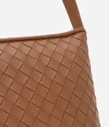 Cartera transversal color marrón con textura tressê, correa de hombro ajustable y cierre de cremallera.