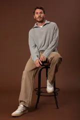 Sweater de punto grueso color gris oscuro, con cuello alto y cierre de cremallera metálica.