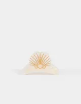 Broche para el pelo color crema con forma de caracola y detalles dorados.