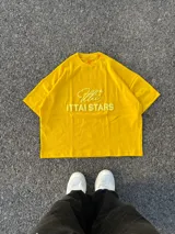 Remera celeste de corte holgado con cuello redondo y estampado en relieve con el logo de la marca y la frase "Ittai Stars".