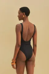 Traje de baño enterizo negro con textura de panal de abeja, escote cuadrado, tirantes anchos y cinturón con hebilla redonda.