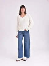 Sweater color crema de tejido de punto con escote en V.