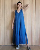 Vestido largo de denim azul con breteles finos, escote en V y aberturas laterales.