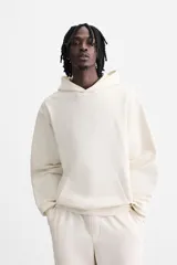 Sudadera con capucha gris confeccionada en tejido de algodón con interior rizo. Tiene manga larga, bolsillo frontal tipo canguro y acabados en rib.