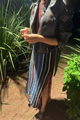 Vestido largo de tejido de punto con rayas verticales en tonos negro, azul, rojo y blanco. Diseño sin mangas con calados.