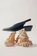 Zapato slingback negro con textura de piel de cocodrilo, punta fina y tacón bloque bajo.