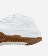 Championes blancos de cuero sintético con suela marrón de goma.