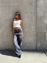 Pantalón de jean de tiro bajo, corte wide leg y lavado oscuro con efecto desgastado.