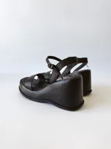 Sandalias negras de cuero con plataforma y pulsera al tobillo.