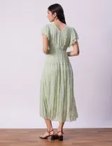 Vestido midi verde agua en tejido calado con escote en V, corte bajo busto y forro interno a tono.