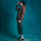 Canguro marrón con capucha, bolsillo tipo canguro y logo estampado en el pecho.