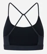 Top deportivo negro confeccionado en microfibra sin estampa, con espalda abierta y breteles finos cruzados.