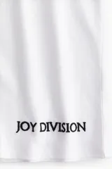 Remera blanca de algodón con estampado frontal de la frase "Love Will Tear Us Apart" y el nombre de la banda Joy Division en color negro.