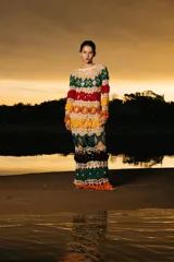 Vestido largo tejido a crochet con diseño calado y rayas horizontales de colores: blanco, verde, rojo, naranja, amarillo, negro y naranja.
