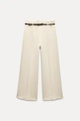 Pantalón culotte color crema, de tiro medio y pierna ancha. Incluye cinturón marrón con hebilla metálica.