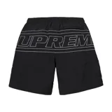 Short de baño negro con cintura elástica y cordón ajustable. Presenta logos grandes de Supreme delineados en blanco en ambas piernas.