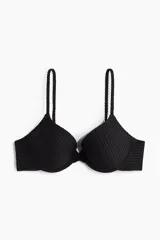Top de bikini negro con textura acanalada, copas preformadas con relleno push-up, breteles finos ajustables y cierre de gancho en la espalda.