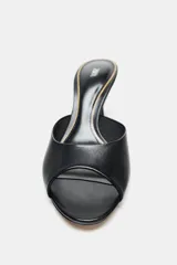 Zapato tipo mule de cuero negro con tira delantera y tacón fino alto. Diseño con punta redonda. Altura del tacón: 8 cm.