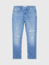 Jean de corte holgado, con rotos en las piernas y lavado azul claro, de diseño inspirado en los 90.
