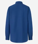 Camisa color ladrillo confeccionada en viscolino, de corte alargado, con cuello clásico, mangas largas, bolsillo delantero y cierre frontal con botones.