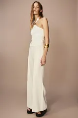 Pantalón blanco de tiro alto y pierna ancha, con cierre lateral oculto.