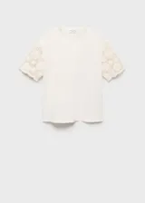 Camiseta blanca de algodón con mangas cortas de crochet y cuello redondo. Diseño recto y calce holgado.