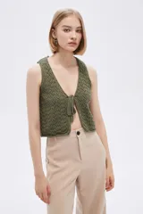 Top sin mangas de algodón color blanco, tejido al crochet, con escote en V profundo y lazo de ajuste en el frente.
