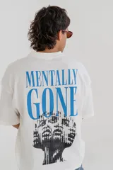 Remera color crudo con estampa en la espalda con la frase "Mentally Gone" en azul y un diseño abstracto en negro.