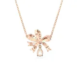 Collar con colgante en forma de lazo bañado en tono oro rosa y adornado con cristales blancos. Presenta una piedra redonda en el centro del lazo y un adorno independiente en forma de pera que cuelga en la parte inferior.