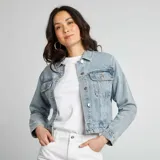 Chaqueta de jean celeste de corte cropped, con cuello clásico, cierre frontal con botones metálicos, bolsillos de parche con solapa en el pecho y mangas largas con puños abotonados.