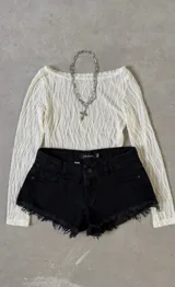 Short de jean negro con terminaciones desflecadas.