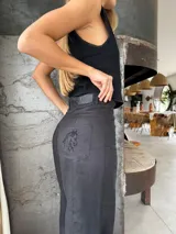 Pantalón sastrero color beige de lino, corte recto y tiro alto, con bordado de caballo en el bolsillo trasero.