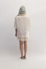 Remerón blanco de cuello bote con encaje integrado y bordado del monograma de la marca a tono. De calce holgado, confeccionado en malla fina compactada y prelavada.