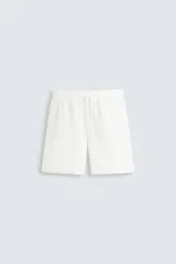 Bermuda de algodón color marrón oscuro, de corte regular fit, con cintura elástica ajustable mediante cordón. Presenta bolsillos laterales y un bolsillo trasero de vivo.