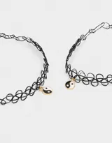 Set de dos chokers elásticos negros con dije de yin yang esmaltado.