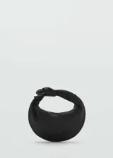 Bolso de mano negro con asa corta con nudo decorativo y asa larga de cadena desmontable.