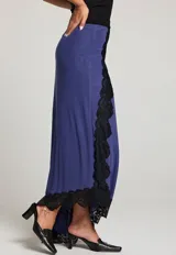 Falda larga azul con dobladillo asimétrico y detalles de encaje negro en los bordes.