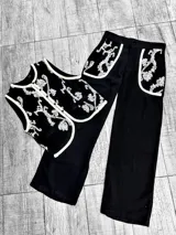 Conjunto de chaleco y pantalón color crudo con bordados de lentejuelas plateadas. El chaleco es sin mangas y el pantalón es de corte recto.