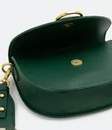 Bolso saddle pequeño color verde esmeralda, con solapa frontal con hebilla metálica dorada y cierre con botón a presión. Incluye correa transversal de grosgrain extraíble y bolsillo interno con cremallera.