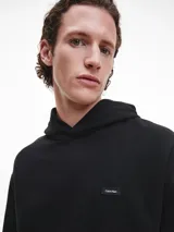 Buzo negro con capucha y bolsillo tipo canguro. Logo de Calvin Klein bordado en el pecho.